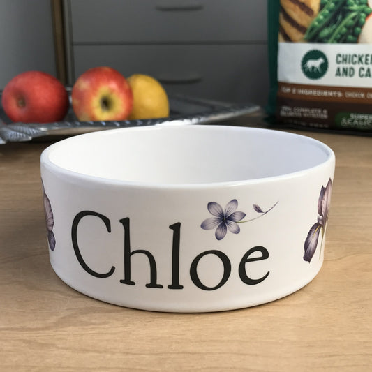 White personalized dog bowl with images of purple flowers.