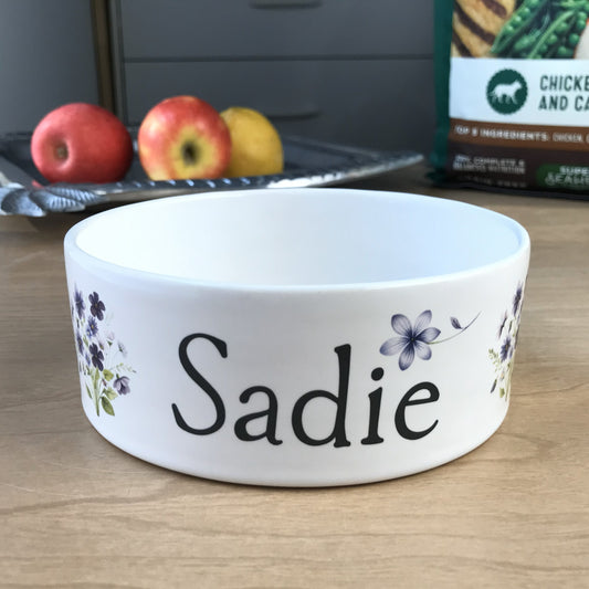 White personalized dog bowl with images of purple flower bouquets.