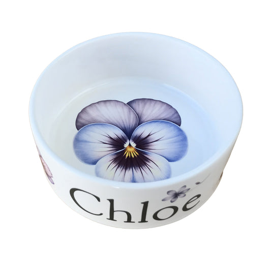 White personalized dog bowl with image of purple flower in center of bowl.